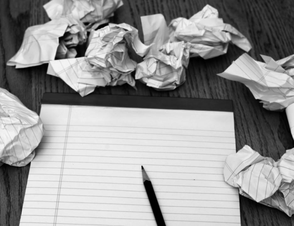 blank page with crumpled notes representing the struggle of writing a eulogy